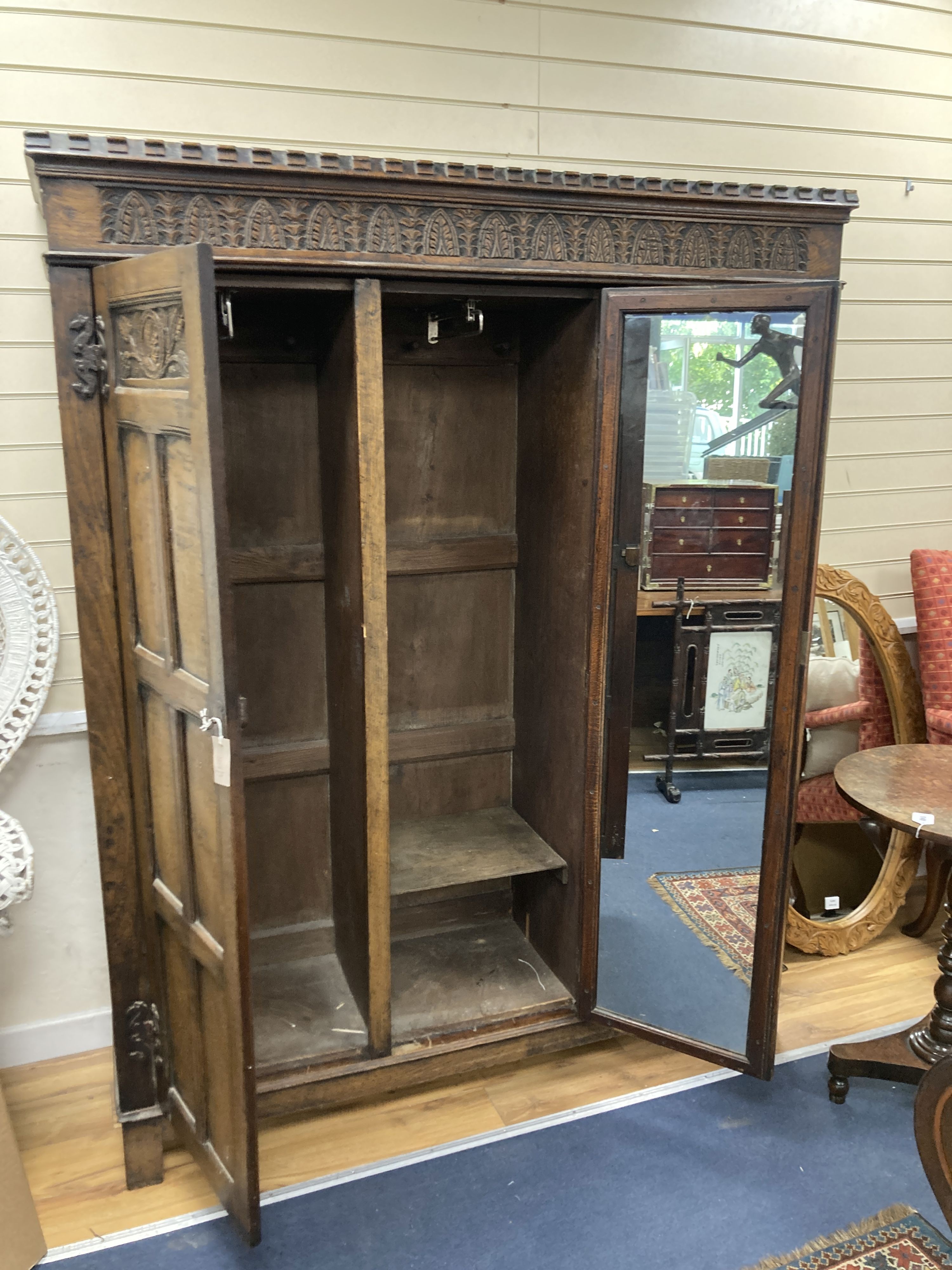 An 18th century style panelled oak triple wardrobe. W-154, D-48, H-193cm.